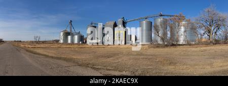 Metallkörnbehälter und ein alter Getreideaufzug mit einer verblassten „Buy Dakota Maid Flour“-Werbung in Cleveland, North Dakota Stockfoto