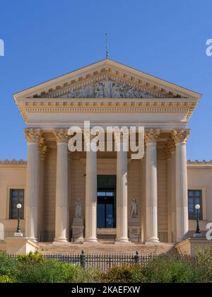 Vertikale Ansicht der neoklassizistischen Steinfassade mit Säulen und Giebel, die die Justiz des historischen Gerichtsgebäudes darstellen, Wahrzeichen von Montpellier, Frankreich Stockfoto