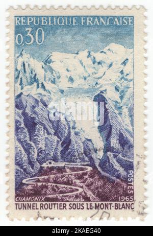 FRANKREICH - 1965. Juli 17: Eine 30 Centimes blaue, violett-blaue und braun-violette Briefmarke, die Straße und Tunnel, Mont Blanc, darstellt. Zur Eröffnung des Mont-Blanc-Tunnels, eines Autobahntunnels zwischen Frankreich und Italien, unter dem Mont-Blanc-Berg in den Alpen. Der Durchgang ist eine der wichtigsten transalpinen Transportwege, insbesondere für Italien, das auf diesen Tunnel angewiesen ist, um bis zu einem Drittel seiner Fracht nach Nordeuropa zu transportieren. Sie reduziert die Strecke von Frankreich nach Turin um 50 Kilometer und nach Mailand um 100 Kilometer Stockfoto