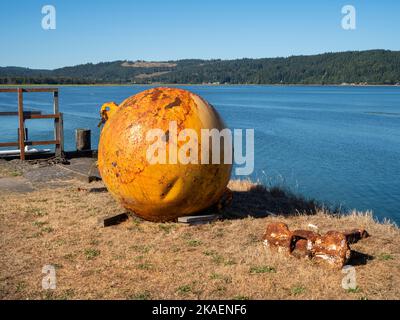 WA22662-00...WASHINGTON - großer, alter, rostiger Schwimmer und Anker, der als farbenfrohe Dekorationen in der Herb Beck Marina an der Quilcene Bay in der Nähe der Stadt Quilcen verwendet wird Stockfoto