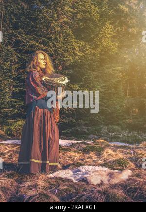 Schöne schamanische Mädchen spielt auf afrikanischen Trommel in der Natur. Stockfoto