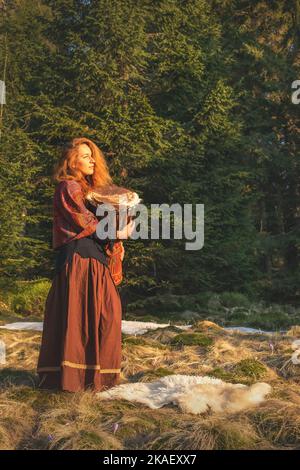 Schöne schamanische Mädchen spielt auf afrikanischen Trommel in der Natur. Stockfoto
