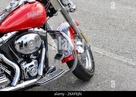 Eine schöne rote und verchromte Harley Davidson Motorrad auf einer Straße geparkt Stockfoto