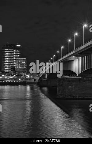 Eine Graustufenaufnahme des Lanxess Hauptquartiers über dem Rhein und der Deutzer Brücke in Köln Stockfoto