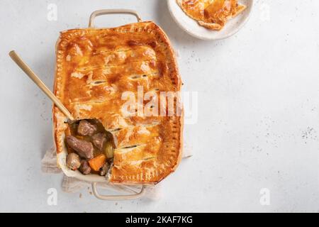 Englischer Rindersteak-Kuchen mit knusprigem Blätterteig in einer Backform Stockfoto