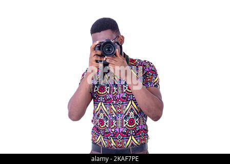 Porträt eines hübschen jungen Fotografen, der mit der Kamera fotografiert. Stockfoto