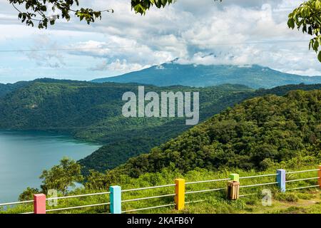 Ein bunter Zaun mit einem schönen See und bewaldeten Mombacho Hügel in der Ferne Stockfoto