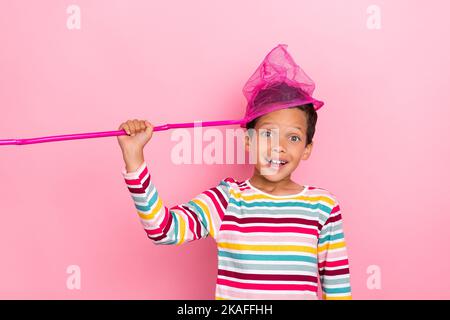 Foto von positiven niedlichen Jungen tragen gestreiften Pullover genießen Sommer Wochenende stehen leeren Raum auf rosa Hintergrund isoliert Stockfoto