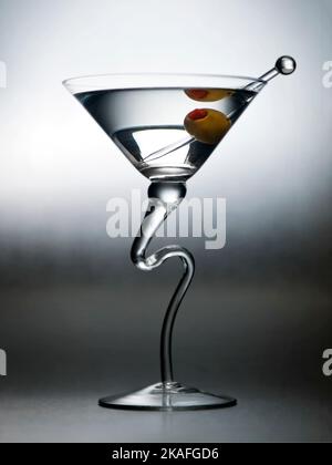 Künstlerisches Martiniglas mit einer Olive und einem Spieß Stockfoto