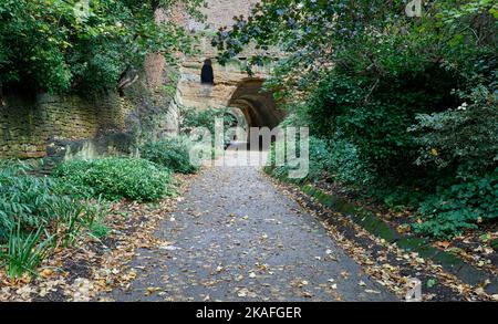 Unterer Eingang zum Park Tunnel, der einen Teil der steinernen Mauer und ungefüttertem Sandstein zeigt Stockfoto