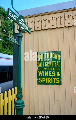 Holzgetäfelte Fassade von Vintage East Grinstead Bahnhof Schuppen mit Emaille Werbeschild auf der historischen Bluebell Railway Linie, Sussex, England. Stockfoto