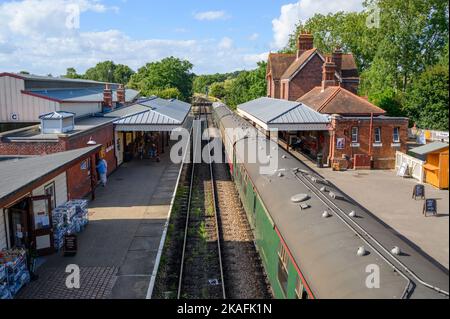 Ein Dampfzug der Bluebell Railway hielt an der Station Sheffield Park, von oben gesehen, an der Fußgängerbrücke an. East Sussex, England. Stockfoto