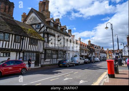 Blick auf die East Grinstead High Street mit ihrer langen Reihe mittelalterlicher Fachwerkhäuser und einer breiten Straße. East Sussex, England. Stockfoto