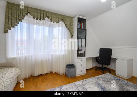 Innenraum eines großen, hell erleuchteten, komfortablen Schlafzimmers mit häuslichem Arbeitsplatz Stockfoto