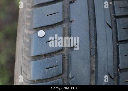 Ein Nagel in einem Autoreifen. Das Rad ist beschädigt. Dies kann zu einer Punktion führen. Stockfoto