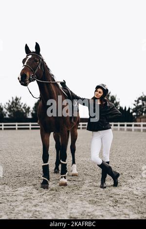 Reitwettbewerbe. Eine Frau und ein Pferd bereiten sich auf ein Rennen vor. Stockfoto