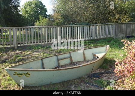 Ein altes verlassene Kanu an einem Holzzaun im öffentlichen Park in Langport, Somerset Stockfoto