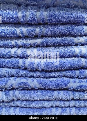 Stapel blauer Frottee-Handtücher. Stapel von textilen Bad-Accessoires. Stockfoto