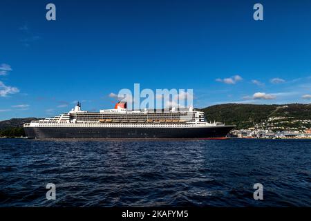 Kreuzfahrt-Schiff Queen Mary 2 in Byfjorden, Abfahrt vom Jekteviksterminalen Kai, im Hafen von Bergen, Norwegen. Stockfoto