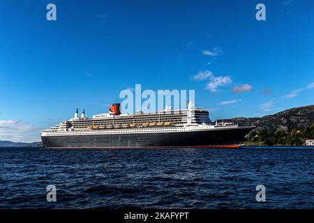 Kreuzfahrt-Schiff Queen Mary 2 in Byfjorden, Abfahrt vom Jekteviksterminalen Kai, im Hafen von Bergen, Norwegen. Stockfoto