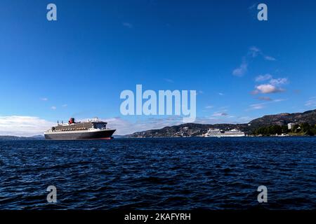 Kreuzfahrt-Schiff Queen Mary 2 in Byfjorden, Abfahrt vom Jekteviksterminalen Kai, im Hafen von Bergen, Norwegen. Das Schiff AIDAsol fährt im Hintergrund ab Stockfoto