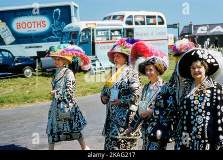 Vier Frauen tragen Jacken und Röcke mit unterschiedlich großen Knöpfen, die auf sie genäht werden, um an der Teilnahme an English Derby, Epsom Downs Racecourse, Epsom, Surrey, England, Großbritannien, Toni Frisell Collection, 3. Juni 1959 Stockfoto