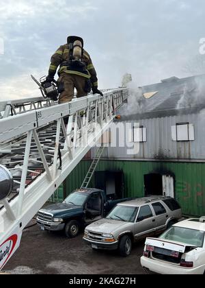 Ein Feuerwehrmann, der der Feuerwehr Duluth zugewiesen wurde, reagiert auf einen Strukturbrand während einer Live-Brandentwicklung im Emergency Response Training Center der Lake Superior College, Duluth, Minnesota, am 27. Oktober 2022. Die Feuerwehr 148., die Feuerwehr Duluth und die höhere Feuerwehr haben gemeinsam einen zweiwöchigen, praktischen Abschlusskurs veranstaltet, der den neuen Feuerwehrleuten helfen soll, in ihrer neuen Karriere erfolgreich zu sein und Trainingspläne für die Feuerwehr in der Region zu standardisieren. (Foto der Air National Guard von Audra Flanagan) Stockfoto