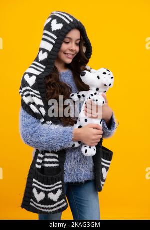 Teenager Kind Mädchen in halten Plüsch Spielzeug isoliert auf gelbem Hintergrund, glückliche Kindheit. Glücklicher Teenager, positive und lächelnde Emotionen des Teenagers. Stockfoto