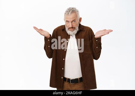 Verwirrter alter Mann, Senior mit Bart und grauen Haaren, Schultern zuckend, ahnungslos aussehend, über weißem Hintergrund gestanden Stockfoto