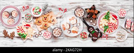 Süße Weihnachtsbonbons und Plätzchen-Tischszene. Ansicht von oben auf einem rustikalen weißen Holz Banner Hintergrund. Fun Urlaub Backkonzept. Stockfoto