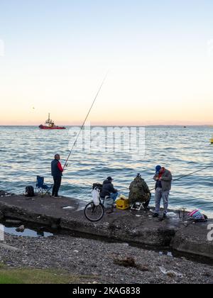 Batumi, Georgia. 10.24.2022 Port-Bereich. Schlepper auf der Straße. Boje in der Hafenbucht. Meer Stadtbild. Lieferung in Georgien. Fischer stehen auf einem Beton pi Stockfoto