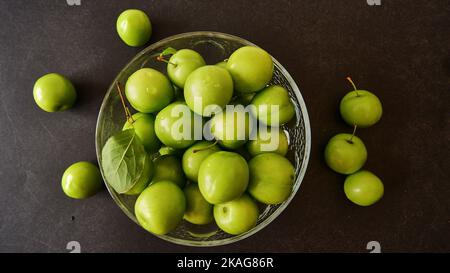 Greengages, Greegages mit Wassertropfen auf der Schüssel und schwarzem Backgorund, Draufsicht. Stockfoto