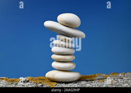 Montón de piedras zen en equilibrio sobre fondo azul Stockfoto