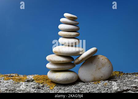 Montón de piedras zen en equilibrio sobre fondo azul Stockfoto