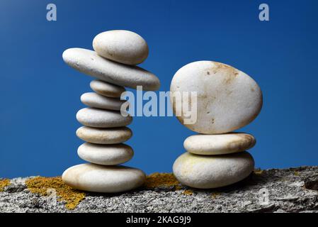 Montón de piedras zen en equilibrio sobre fondo azul Stockfoto