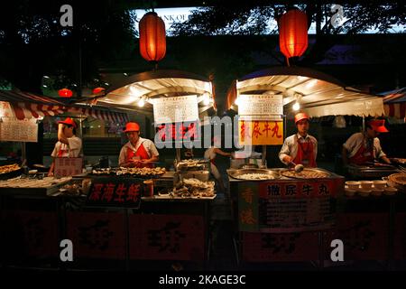 Auf dem Donghuamen Nachtmarkt in Peking, China, warten Anbieter auf Kunden. Stockfoto