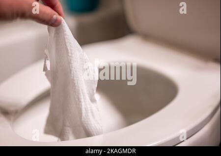 Einweg-Wischtücher werden auf der Toilette heruntergespült, wo sie Verstopfung und Probleme mit der Abwasserbehandlung verursachen können. Stockfoto