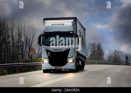 Der neue weiße Iveco S-Way-Lkw zieht im dramatischen Licht des Spätherbst den Sattelauflieger auf dem Highway 52. Salo, Finnland. 28. Oktober 2022. Stockfoto