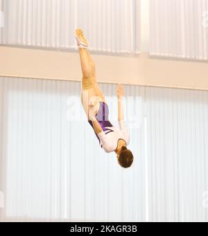 Mädchen trainieren im Trampolin und springen in einem stationären Raum Stockfoto