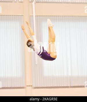 Mädchen trainieren im Trampolin und springen in einem stationären Raum Stockfoto