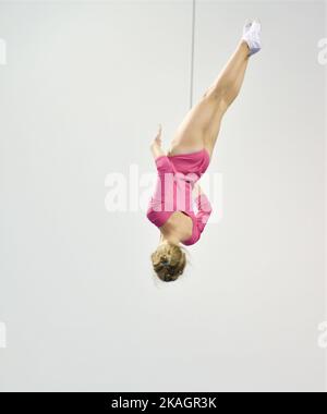 Mädchen trainieren im Trampolin und springen in einem stationären Raum Stockfoto