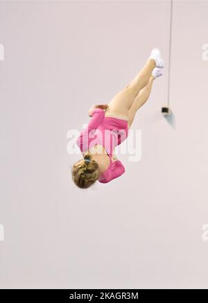 Mädchen trainieren im Trampolin und springen in einem stationären Raum Stockfoto