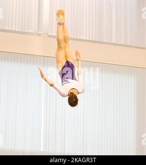 Mädchen trainieren im Trampolin und springen in einem stationären Raum Stockfoto