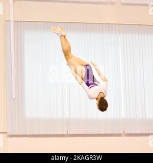 Mädchen trainieren im Trampolin und springen in einem stationären Raum Stockfoto