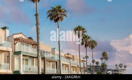 Panorama Puffy Clouds at Sunset Reihe von mehrstöckigen Häusern mit angeschlossener Garage in La Jolla, Kalifornien. Häuser mit Glasgeländer an den Balkonen A Stockfoto