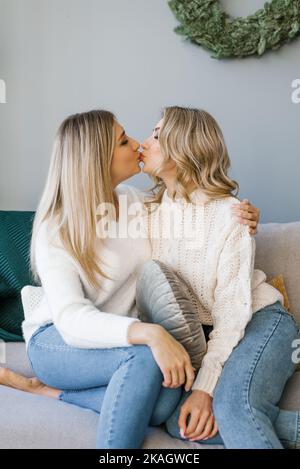 Schöne Freundinnen oder Schwestern für die Feier von Weihnachten genießen den Komfort von zu Hause. Wir gratulieren einander zu Weihnachten und Neujahr und Stockfoto