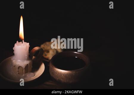 Heilige Kommunion symbolisiert Blut und Fleisch Jesu Christi Letztes Abendmahl Wein, Brot und eine hell leuchtende Kerze auf dem Kerzenständer Stockfoto