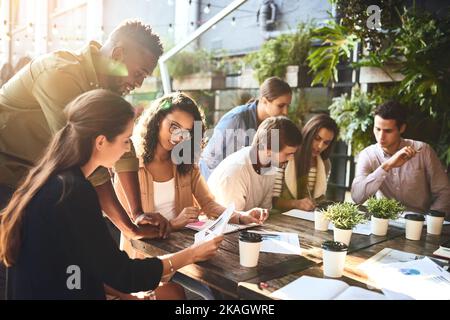 Eine Gruppe von Kollegen, die sich draußen in einem Café treffen. Stockfoto