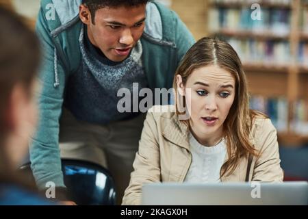 Sich gegenseitig bei ihren Aufgaben helfen. studenten arbeiten auf dem Campus gemeinsam an einem Laptop. Stockfoto