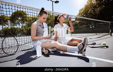 Frau, Freunde und Tennis in einer Sportpause, Entspannung oder Auszeit zusammen auf dem Platz im Freien. Fitness Frauen in entspannen nach dem Sport Spiel, Spiel Stockfoto